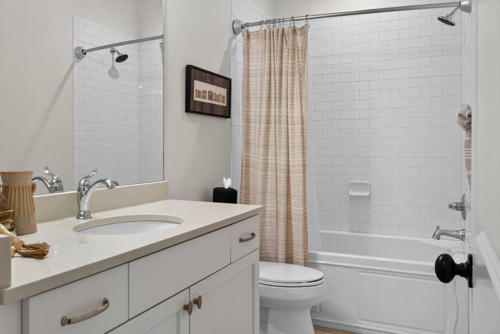 Clean bathroom with white subway tile and quartz vanity, real estate photography in Atlanta, GA