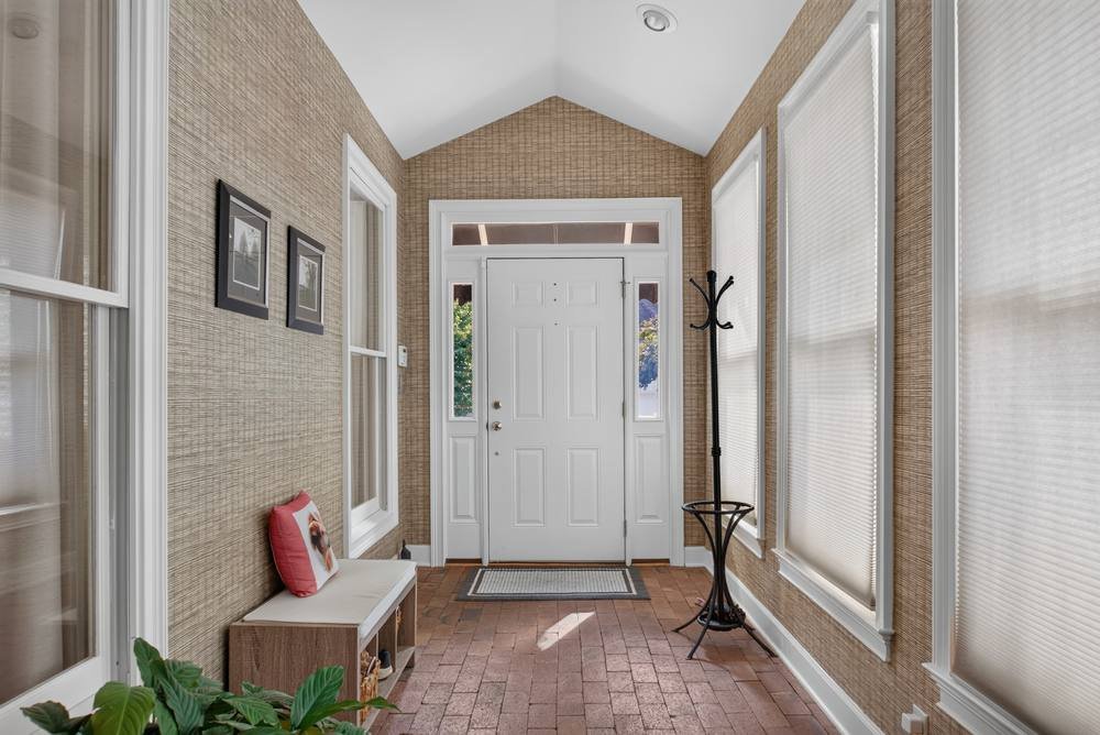 Bright home entry foyer with brick floor and vaulted ceiling, real estate photography in Covington, GA