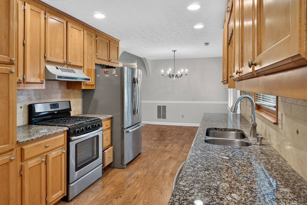 Galley kitchen with wood cabinets, granite counters and hardwood floors, real estate photography in metro Atlanta