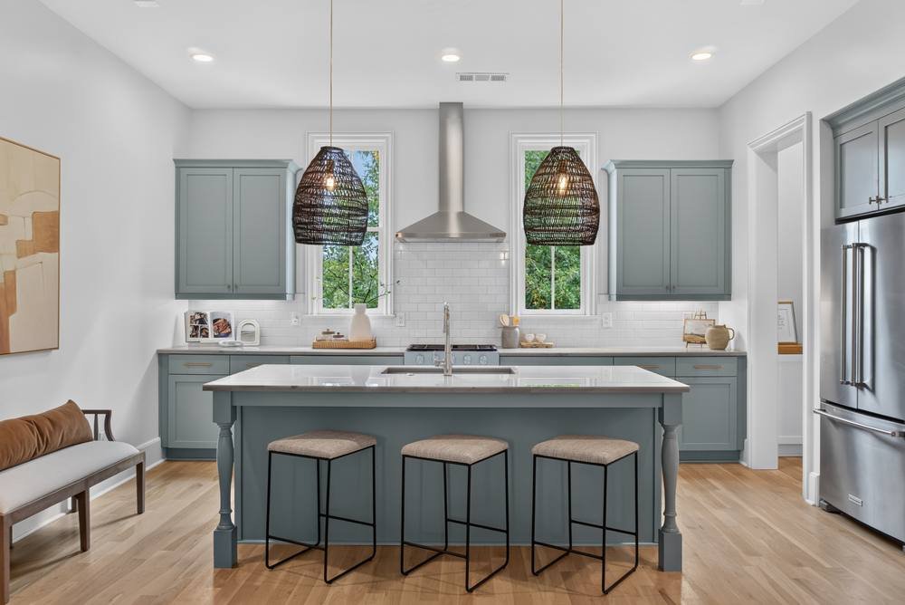 Kitchen with blue-gray island, pendant lights and subway tile backsplash, real estate photography in Covington, GA