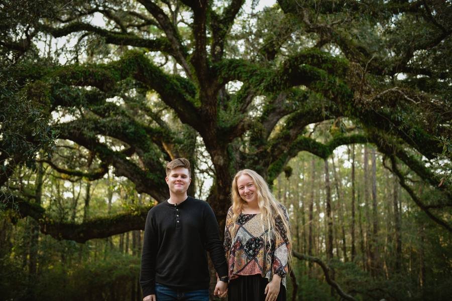 Nic, owner of Under the Oak real estate photography, standing beneath a large live oak tree
