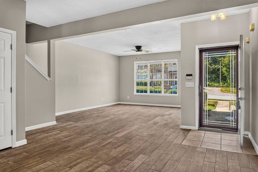 Open main level with ceiling fan and large front window, real estate photography in East Metro Atlanta