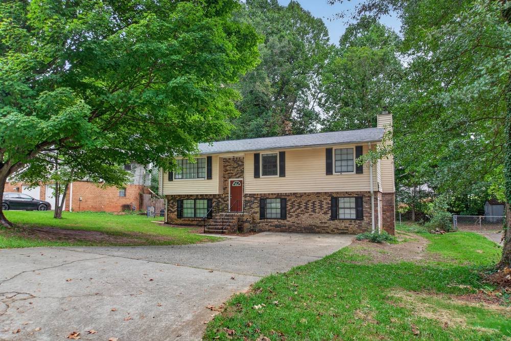 Split-level brick and siding home with red front door, real estate photography in East Metro Atlanta